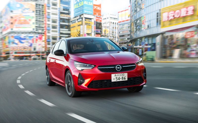 Un Opel Corsa de color vermell en un carrer del Japó